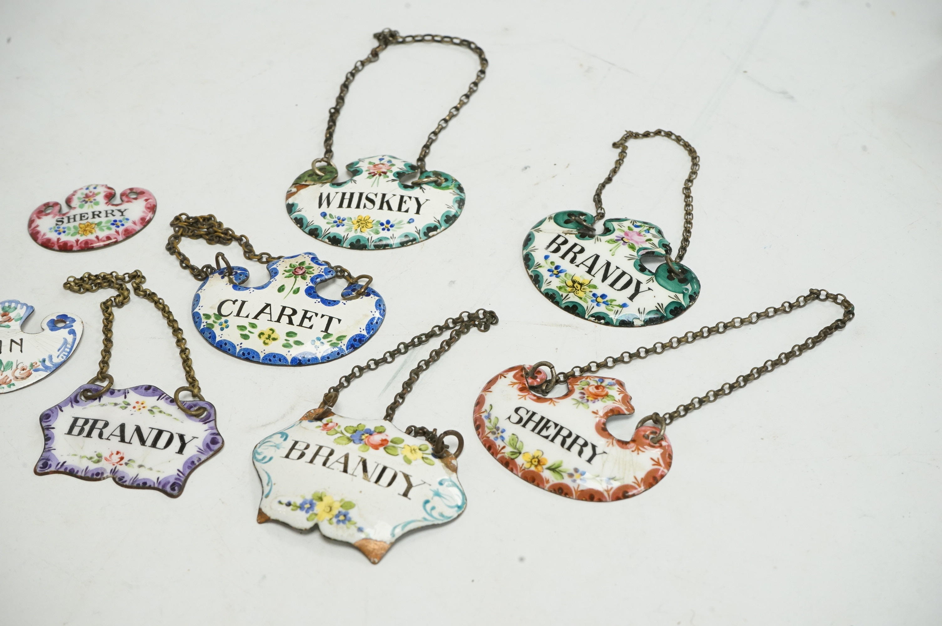 A collection of enamelled wine and spirit decanter labels. Condition - some damage to the enamel
